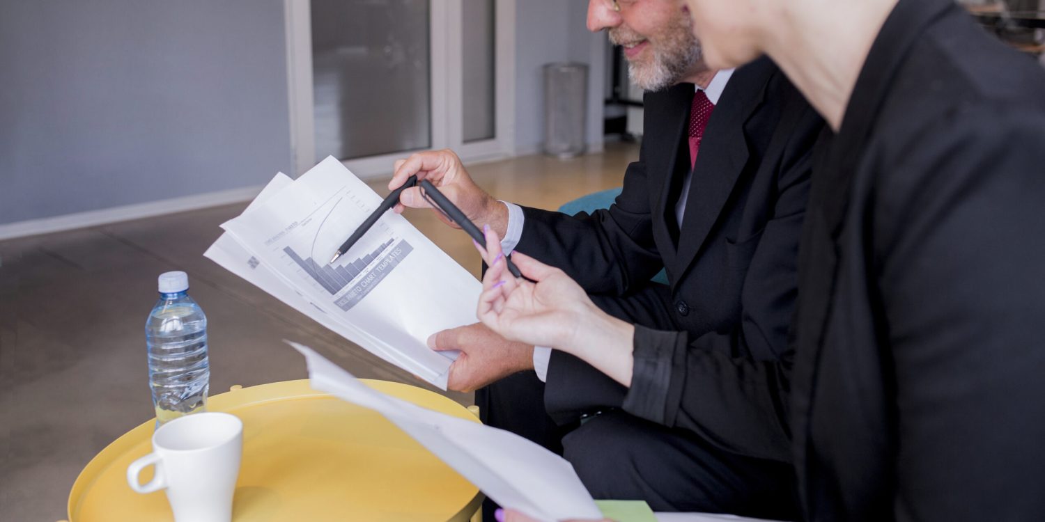 business-man-woman-sitting-desk-talking-about-reports-finance