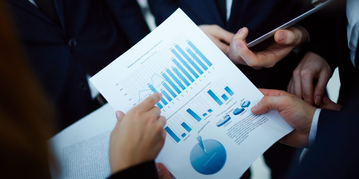 Image of business document held by man and being pointed at by woman at meeting