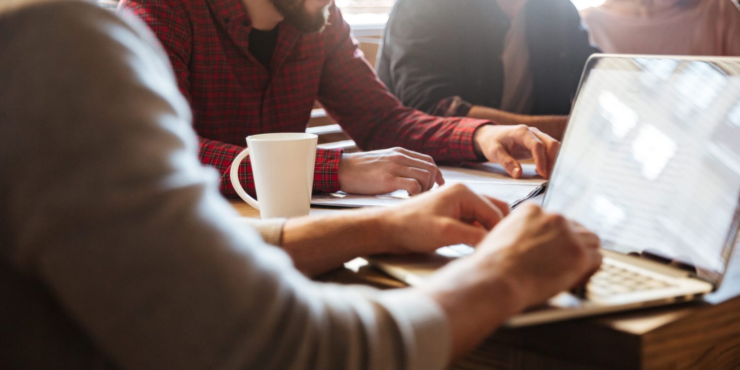Concentrated colleagues sitting in office and coworking. Cropped photo of young concentrated colleagues sitting in office and coworking.